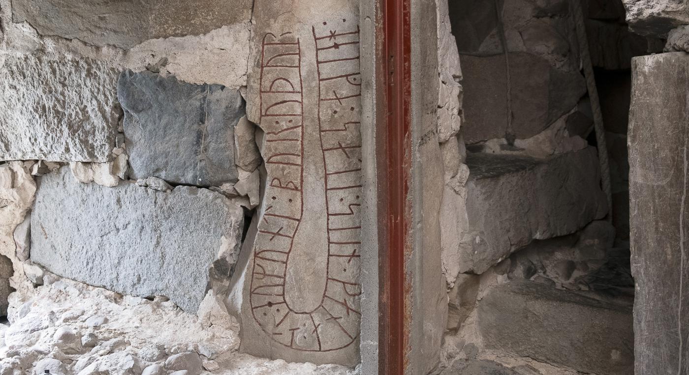 En runsten i en stenvägg.