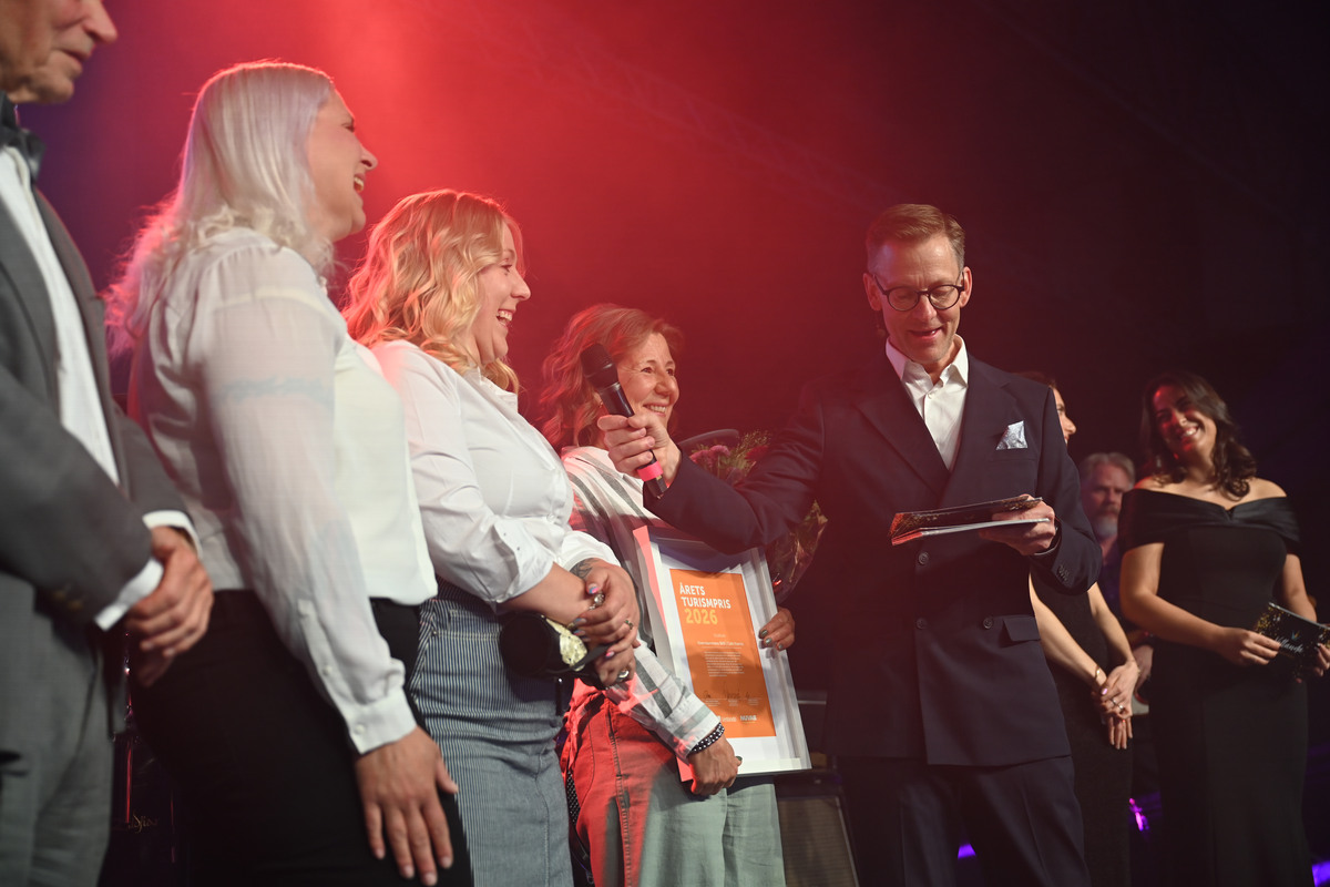 Niclas Lindqvist håller fram en mikrofon mot en av vinnarna i kategorin Årets turismpris.