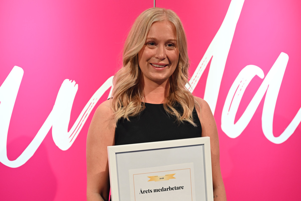 Malin Wirebrand står framför en rosa fotovägg och håller i ett diplom och en blombukett.