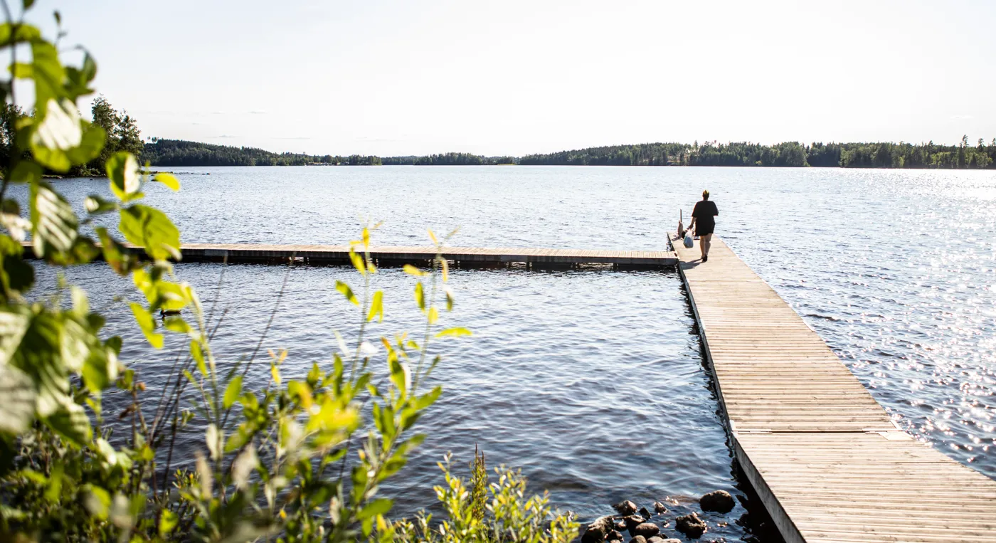 En person som står på en brygga vid Kristinelundsbadet.