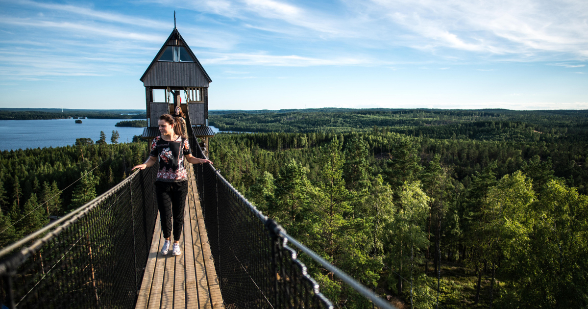 Två personer som går över en hängbro.