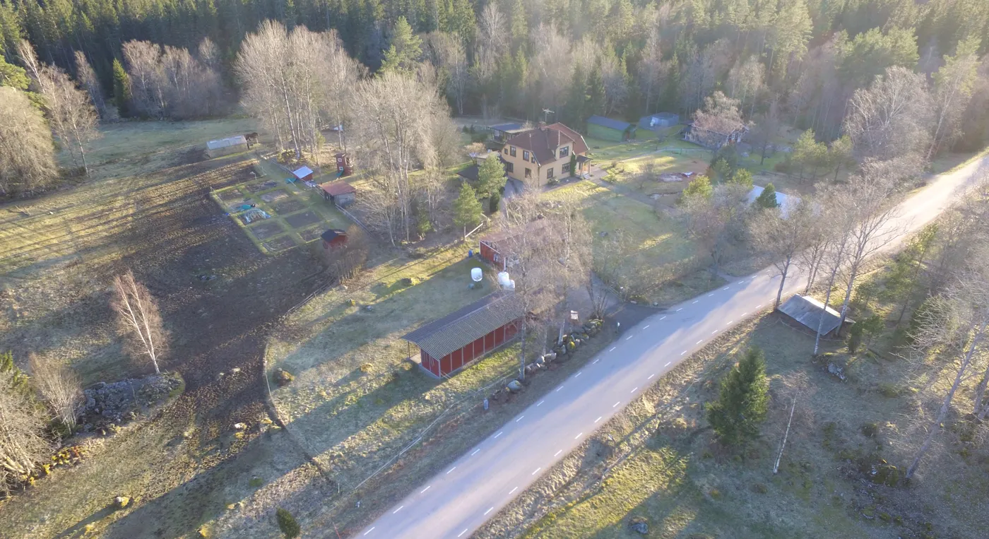 En flygbild över en gård och en väg.
