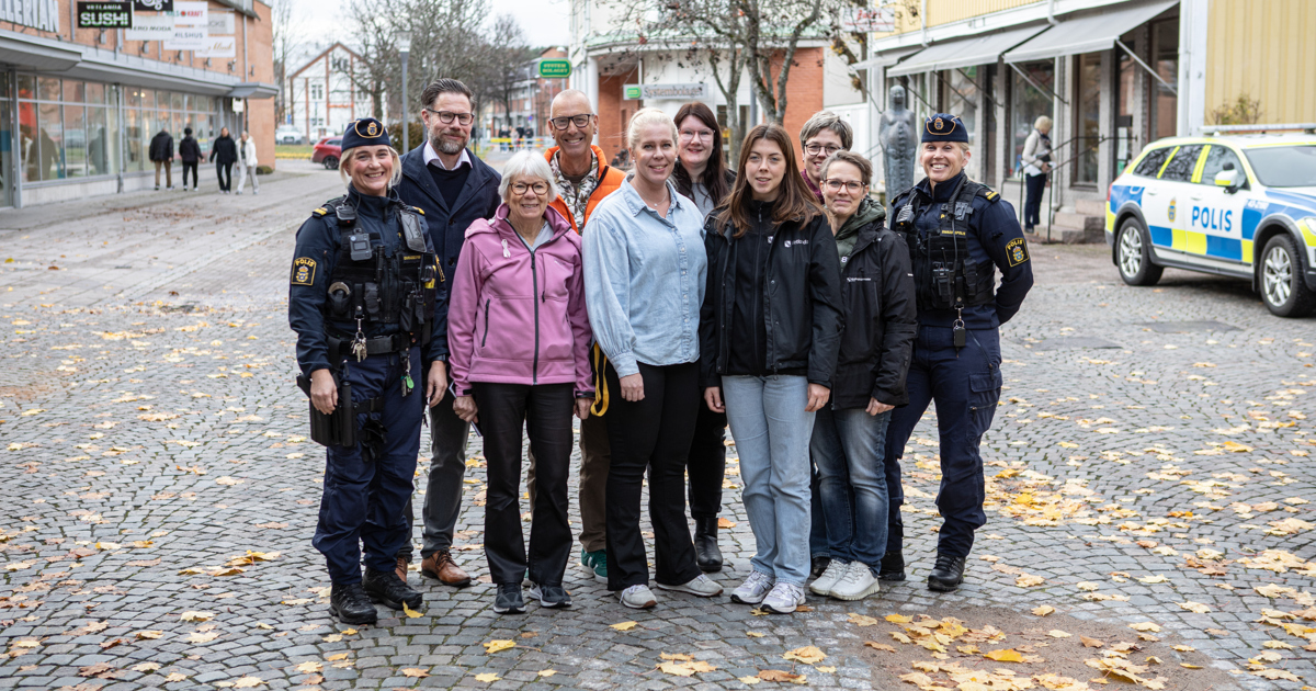 En grupp människor, bland annat två med polisuniform, står i en grupp.