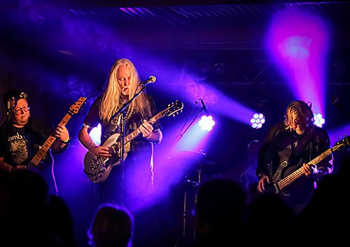Rockband på scen i lila strålkastarljus