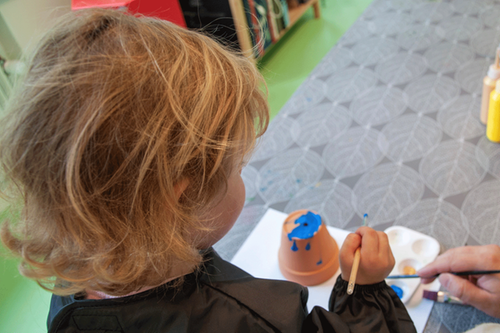 Barn med pensel som målar.